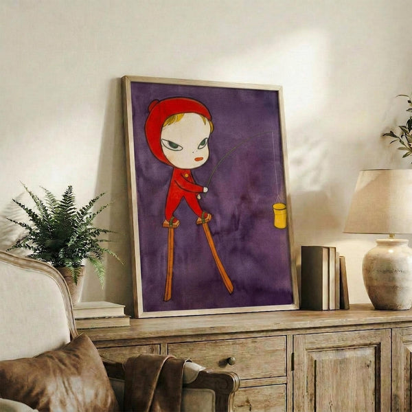 May include: Framed artwork displaying a stylized character in red hooded clothing on wooden stilts against a purple background, positioned on a rustic wooden sideboard alongside potted plants, books, and ceramic vessels in a cozy living room setting with neutral tones and natural lighting.