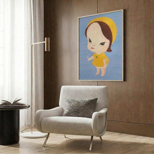 May include: Contemporary artwork featuring a stylized child character with large eyes, brown hair, and yellow dress against blue background, displayed in light wood frame on warm wood paneled wall. Modern beige armchair with geometric patterned pillow sits below, accompanied by brass floor lamp and dark side table with open book. Neutral curtains frame window on left.