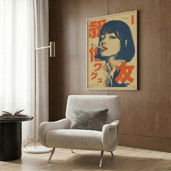 May include: Framed vintage-style poster featuring a woman with dark bob haircut smoking a cigarette, rendered in cream, orange and blue tones with Japanese text, displayed on wood-paneled wall above beige upholstered armchair with geometric patterned pillow, beside modern brass floor lamp and dark side table with open book.