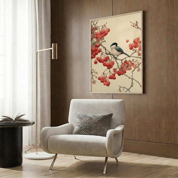 May include: Vintage Japanese bird artwork displayed on wood-paneled wall above beige upholstered chair with geometric pillow. Print shows small songbird perched on branch with clusters of red berries against cream background. Modern reading corner with brass floor lamp and dark side table.