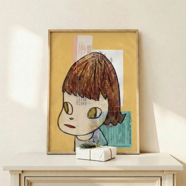 May include: Framed artwork displaying a stylized illustration of a young girl with brown bob haircut and large yellow-green eyes, created using mixed media with collaged document fragments on yellow background. Wooden frame sits on white wooden surface beside small wrapped gift with evergreen sprig. Minimalist white wall background.