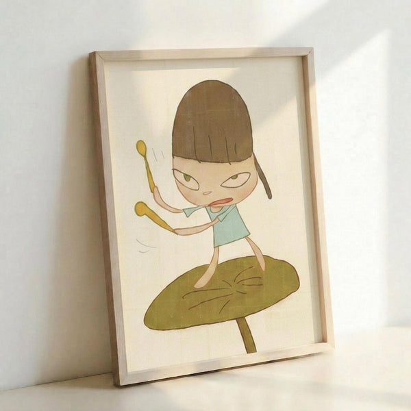 May include: Framed artwork showing a cartoon-style girl with brown bob haircut and green eyes, wearing a light blue tank top, balancing on a large green leaf while holding two yellow drumsticks with arms raised. The illustration has a whimsical, minimalist style with soft colors on cream background, displayed in a light wood frame leaning against a white wall.