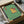 May include: Framed cartoon illustration of a golden retriever wearing sunglasses sitting on a toilet while reading a red book, set against green tiled bathroom walls. The artwork is packed in brown cardboard shipping box with protective wrapping materials visible around the black frame.