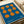May include: Blue poster with abstract orange geometric shapes resembling connected circles and organic forms, displayed on white paper with ribbon nearby. Clean minimalist design with "Bauhaus" and "1919" text at bottom in white lettering against the vibrant blue background.