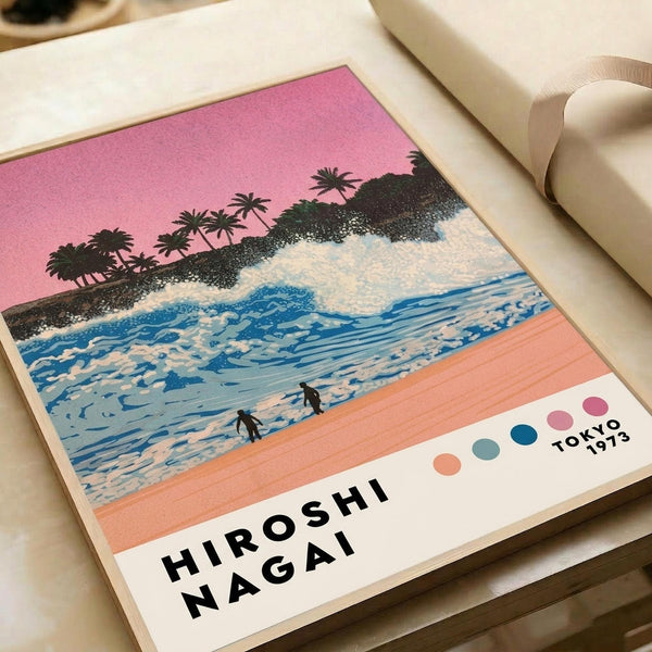 May include: Retro-style poster print featuring tropical beach scene with pink sunset sky, palm trees silhouetted against coastline, blue ocean waves, and two small figures on coral-colored sand. White border with artist name and Tokyo 1973 text, plus small color palette dots. Print shown flat on neutral surface with white ribbon nearby.