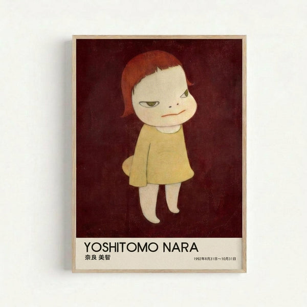 Framed art print featuring a stylized illustration of a pale child-like figure with orange-red hair wearing a yellow dress against a deep burgundy background. The figure has large eyes and a subtle smile. Below the artwork is text reading "YOSHITOMO NARA" in black letters with Japanese characters and exhibition dates "1992年8月31日～10月31日". The print is displayed in a light wooden frame against a white wall.