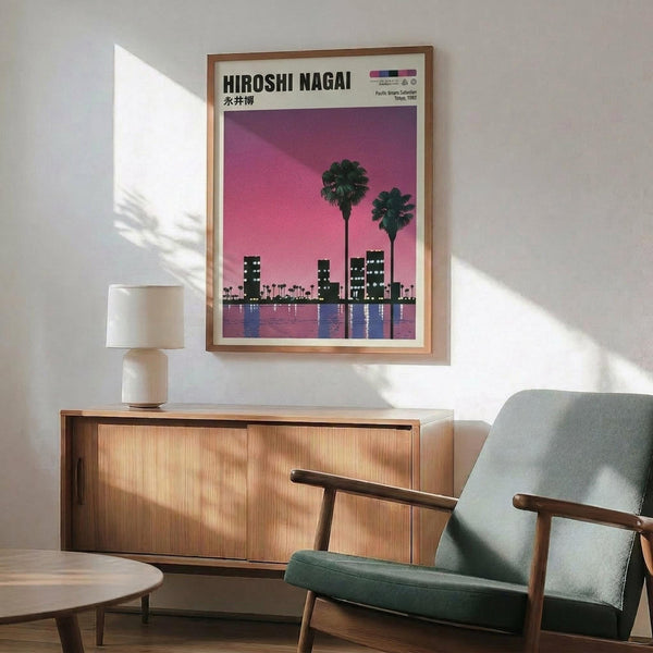 May include: Framed poster with pink-purple sunset sky, silhouetted palm trees, city skyline with lit buildings reflected in water, displayed above wooden sideboard with ceramic lamp in modern living room setting with gray upholstered chair and natural lighting creating window shadows on white wall.