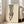 May include: Framed minimalist fashion artwork featuring black and white striped pants and red high heel shoes on cream background, displayed in light wood frame leaning against white wall next to beige upholstered sofa in bright living room with large windows