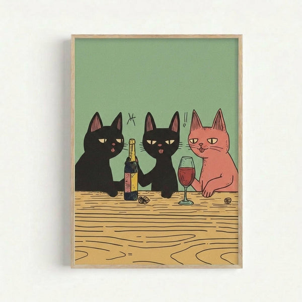 Framed art print showing three stylized cats sitting at a wooden table with wine. Two black cats and one orange cat are depicted in a simple, cartoon style against a sage green background. A wine bottle, glass of red wine, and small objects sit on the wood-grain table. The print is displayed in a light wood frame on a white wall.
