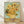 May include: Framed reproduction of Van Gogh's sunflowers painting showing vibrant yellow blooms with thick brushstrokes in a yellow vase against turquoise background, displayed in light wood frame leaning against white wall on wooden floor with natural lighting creating soft shadows