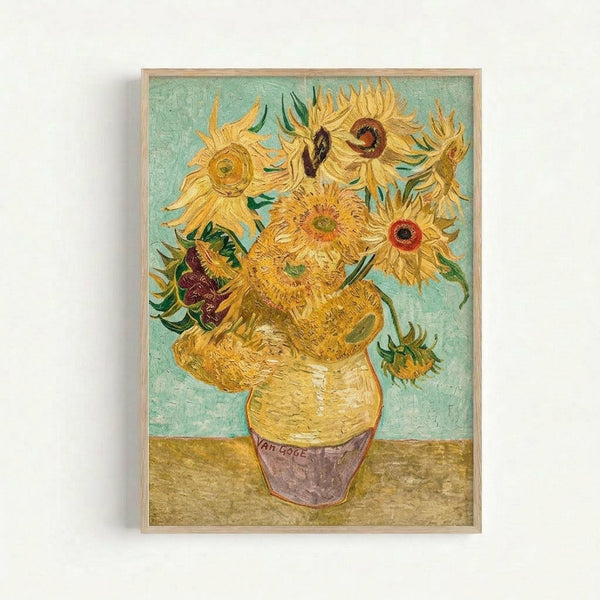 Framed reproduction of Van Gogh's sunflowers painting showing vibrant yellow sunflowers in various stages of bloom arranged in a ceramic vase. The artwork features thick, expressive brushstrokes with a turquoise background and golden table surface. The sunflowers display rich yellows, oranges, and browns with green leaves, all rendered in Van Gogh's distinctive post-impressionist style. Housed in a simple light wood frame against a white wall.
