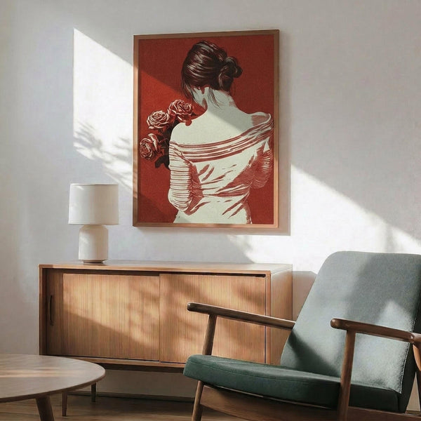 May include: Framed red and cream poster showing woman with upswept hair viewed from behind, wearing draped garment and holding roses, displayed above wooden sideboard with white table lamp in modern living room with mint green armchair and round coffee table, natural sunlight creating shadows on white wall