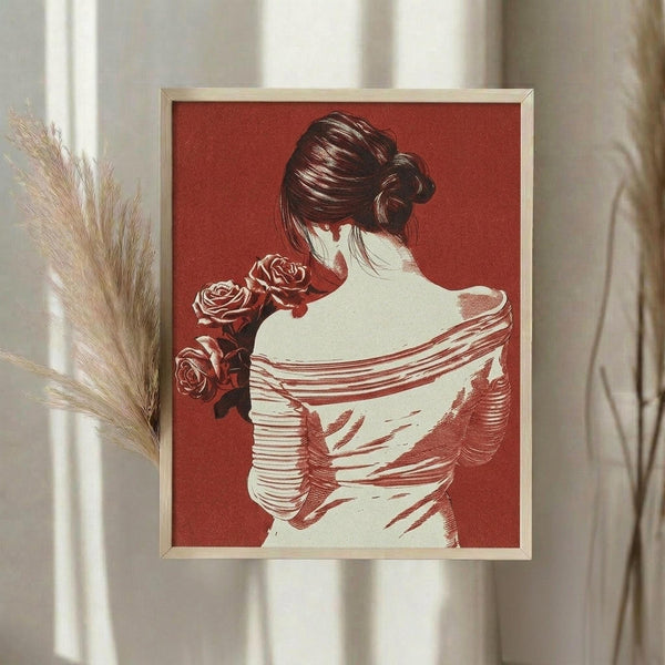 May include: Framed art print displaying a woman in profile view wearing a white draped garment and holding red roses, rendered in red and cream tones against a terracotta background. The print is shown in a light wood frame hanging on a white wall next to dried pampas grass in soft natural lighting.