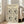 May include: Framed art print featuring black line drawings of various faces and botanical elements on cream background, displayed in light wood frame leaning against white wall next to beige upholstered chair in bright, minimalist living room with hardwood floors and large windows