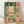 May include: Framed reproduction of Matisse's Fauve painting showing an interior view through open French doors to a harbor scene with boats. Vibrant greens, pinks, and oranges with bold brushstrokes. The artwork is displayed in a light wood frame against white walls on wooden flooring, with natural lighting casting soft shadows.