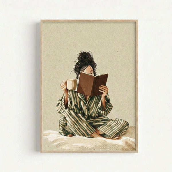 Framed illustration of a person with dark curly hair in a messy bun, sitting cross-legged while reading a brown book and holding a cream-colored mug. They wear green and cream striped pajamas or loungewear. The artwork has a warm, cozy aesthetic with earth tones on a cream textured background. The piece is displayed in a light wood frame against a white wall.