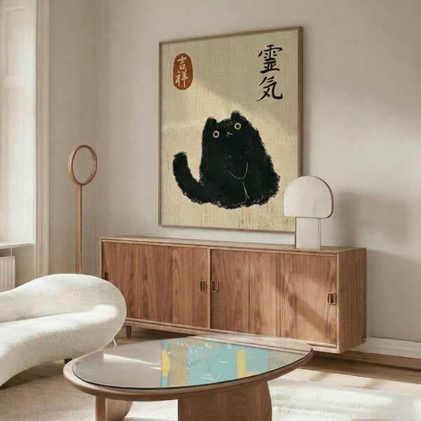 May include: Modern living room interior featuring a framed poster with Japanese calligraphy and a black ink-style cat illustration on cream textured background. The artwork hangs above a wood sideboard with sliding doors, flanked by a white curved chair, brass floor lamp, and white table lamp. An oval glass coffee table sits in the foreground with abstract blue and yellow artwork visible on its surface.