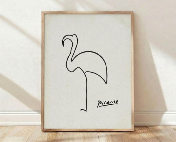 May include: Framed minimalist line drawing of a flamingo in black ink on white paper, displayed in light wood frame against white textured wall with natural lighting and shadows, positioned on light wooden floor