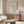 May include: Minimalist line drawing of a flamingo with Picasso signature displayed in thin wooden frame above walnut credenza in modern living room with cream walls, white sculptural chair, glass coffee table, and contemporary lighting fixtures