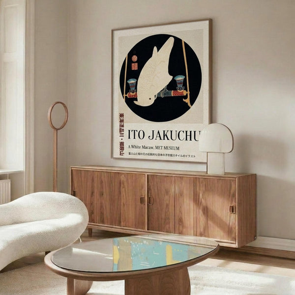 May include: Japanese art poster featuring white macaw in black circle on beige background, displayed in wooden frame above walnut credenza. Modern living room with cream upholstered chair, glass-top coffee table, brass floor lamp. Clean minimalist styling with natural wood tones and neutral colors throughout the space.