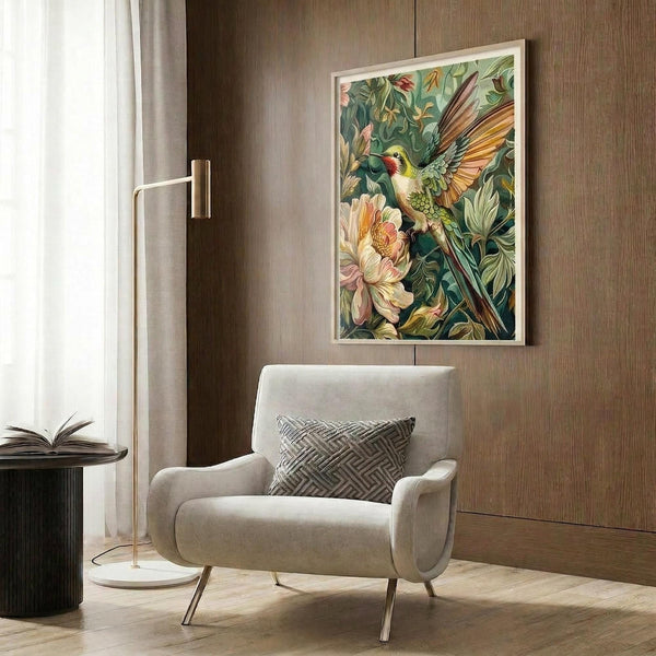 May include: Framed botanical artwork featuring a colorful hummingbird with spread wings among lush tropical flowers and foliage in greens, yellows, and coral tones. The print hangs on a wood-paneled wall above a cream upholstered armchair with geometric pillow. A brass floor lamp and side table with open book complete the warm, modern reading nook with natural lighting from nearby window.