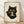 May include: Framed poster print featuring a black cat with large golden eyes eating noodles from a dark bowl using chopsticks, rendered in Japanese ukiyo-e woodblock print style with beige aged paper background and red seal stamps, displayed in light wood frame against white textured wall on wooden floor