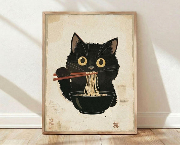 May include: Framed poster print featuring a black cat with large golden eyes eating noodles from a dark bowl using chopsticks, rendered in Japanese ukiyo-e woodblock print style with beige aged paper background and red seal stamps, displayed in light wood frame against white textured wall on wooden floor