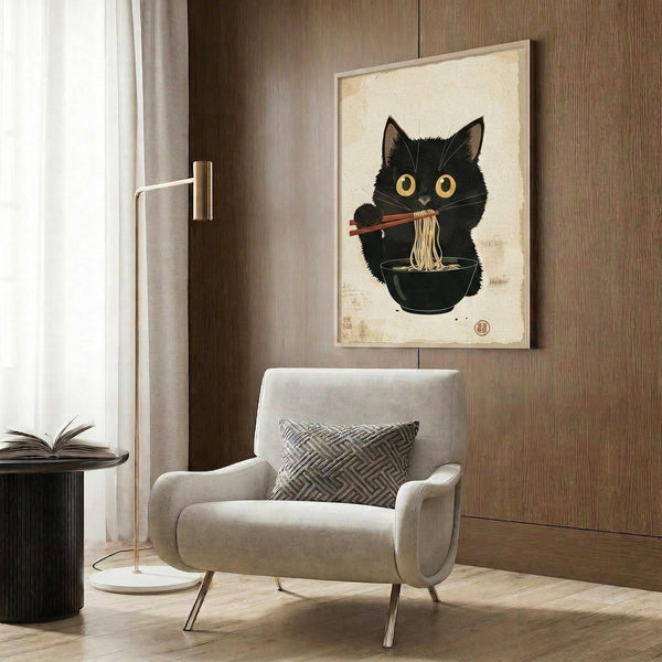 May include: A framed poster featuring a black cat with large golden eyes eating ramen noodles with chopsticks from a dark bowl, rendered in traditional Japanese ukiyo-e art style on cream-colored paper. The artwork hangs on a wood-paneled wall above a beige upholstered armchair with geometric throw pillow, beside a brass floor lamp and dark round side table with an open book.