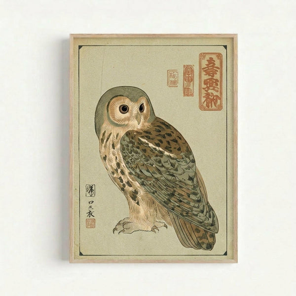 Framed vintage-style Japanese woodblock print featuring a detailed owl with brown and green feathers, pale yellow breast, and large dark eyes. The artwork has a cream background with red Japanese calligraphy stamps in the upper right corner and artist signature on the left. The print is displayed in a light wooden frame against a white wall.