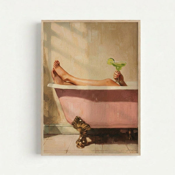 A framed vintage-style poster showing a person relaxing in a pink clawfoot bathtub, holding a green margarita with lime garnish. The artwork has warm, golden tones with soft lighting streaming through the bathroom. The ornate brass feet of the antique tub are visible against white tile flooring. The print is displayed in a light wood frame against a white wall.