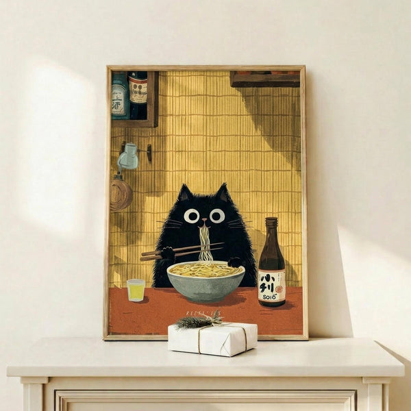 May include: Framed poster print displayed on white wooden shelf featuring a black cat with large white eyes eating ramen noodles with chopsticks. The illustration shows a cozy Japanese-style kitchen scene with bamboo walls, bottles of sake, and cooking utensils on shelves. The cat sits at a red table with a bowl of noodles, a bottle labeled "SOJO," and a small glass. A wrapped white gift box sits on the shelf below the artwork.
