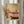 May include: Framed artwork showing person's legs relaxing in pink clawfoot bathtub, holding green margarita cocktail, displayed on light wall next to dried pampas grass stems. Warm vintage-style illustration in golden wood frame with soft natural lighting from nearby window.