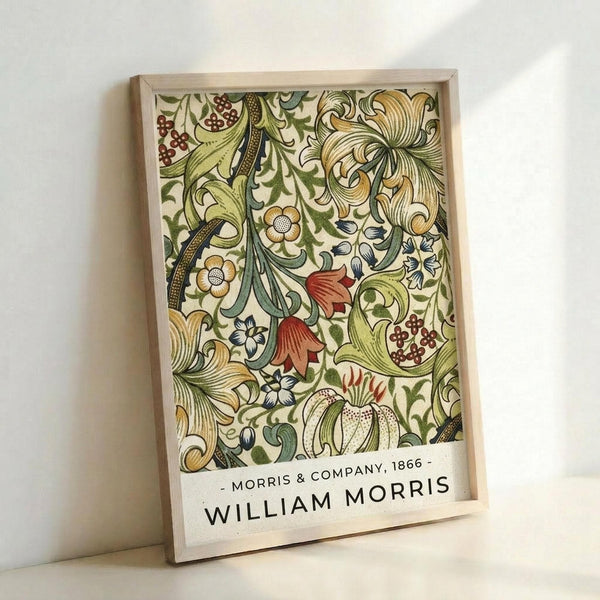 May include: Framed botanical art print with intricate floral pattern in greens, golds, and reds featuring stylized flowers, leaves, and berries in Victorian decorative style. Light wood frame displays against white wall, showing detailed ornamental design with flowing organic motifs and rich earth tone colors throughout the vintage-inspired wallpaper pattern.