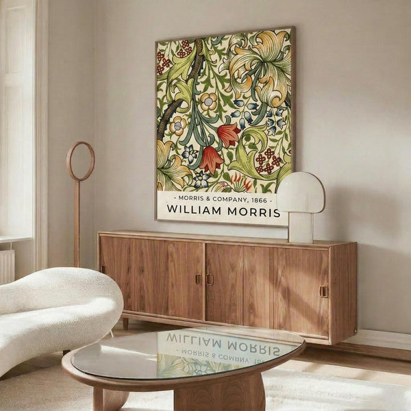 May include: Framed botanical art print featuring intricate green foliage, red berries, and cream flowers in Victorian decorative style, displayed above a walnut wood credenza with brass handles. Modern white swivel chair and glass-top coffee table visible in minimalist living room with beige walls and natural lighting.