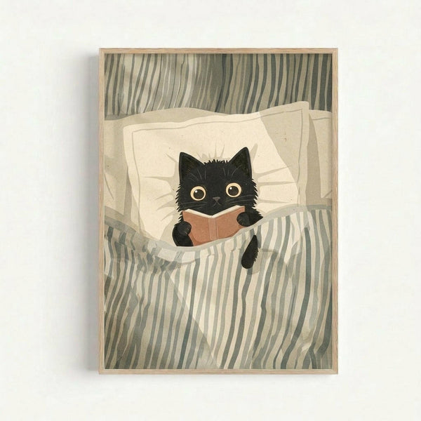 May include: Framed artwork showing a black kitten with large golden eyes reading a small orange book while tucked into bed with white pillows and green striped bedding. The illustration has a soft, painted style with muted earth tones and is displayed in a light wood frame against a white wall.