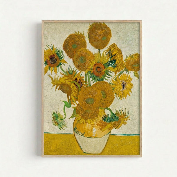 A framed reproduction of Van Gogh's iconic sunflowers painting featuring vibrant yellow and orange blooms arranged in a ceramic vase. The artwork displays the artist's characteristic thick brushstrokes and swirling textures against a pale background with a yellow table surface. The sunflowers show various stages of bloom with detailed petals and dark centers, all rendered in warm golden tones with green accents on stems and leaves.
