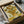 May include: Framed reproduction of Van Gogh's sunflowers painting showing vibrant yellow blooms in a vase, displayed in a black frame being unpacked from a cardboard shipping box with protective wrapping paper and wooden corner guards on a white surface