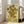 May include: Framed reproduction of Van Gogh's famous sunflowers painting leaning against white wall in bright living room. Yellow and orange sunflowers in ceramic vase against pale yellow background, displayed in light wood frame. Gray upholstered sofa and large windows with natural light visible in modern interior setting.