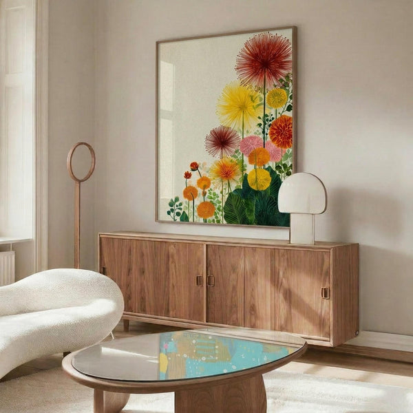 May include: Colorful botanical art print with vibrant red, yellow, and orange sunburst flowers and green leaves, displayed in thin wooden frame above mid-century walnut credenza. Modern living room setting features cream upholstered swivel chair, oval glass coffee table with iridescent surface, white mushroom table lamp, and minimalist floor mirror against neutral beige walls.