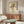 May include: Framed art print on cream background featuring colorful hand-drawn flowers in red, orange, yellow, blue and green with black line drawing of hands holding bouquet. Displayed above mid-century walnut credenza in modern living room with white curved chair, brass floor lamp, glass coffee table and natural lighting.
