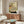 May include: Japanese woodblock print artwork featuring a striped cat drinking from a decorative ceramic bowl, with potted plants in background and Japanese text, displayed in thin frame above wooden sideboard in modern living room with white curved chair, floor lamp, and glass coffee table
