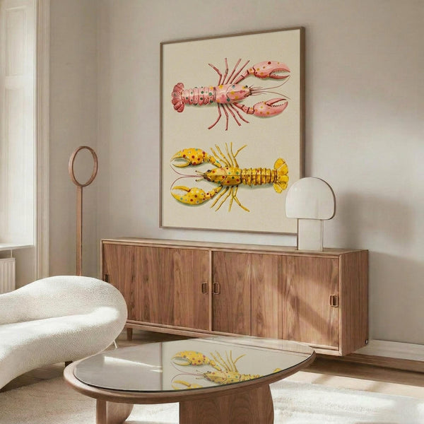 May include: Framed marine illustration print featuring two colorful lobsters - one pink with green spots and one yellow with red spots - displayed above a mid-century modern walnut credenza. Room setting shows white upholstered chair, round glass coffee table, white table lamp, and neutral walls with natural lighting creating shadows.