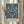 May include: Framed poster print featuring intricate blue floral damask pattern on cream background, displayed in light wood frame on neutral wall beside dried pampas grass stems. Victorian-style botanical design shows symmetrical arrangement of large blooms, grape clusters, sunflowers and ornate leaves creating decorative wallpaper motif.
