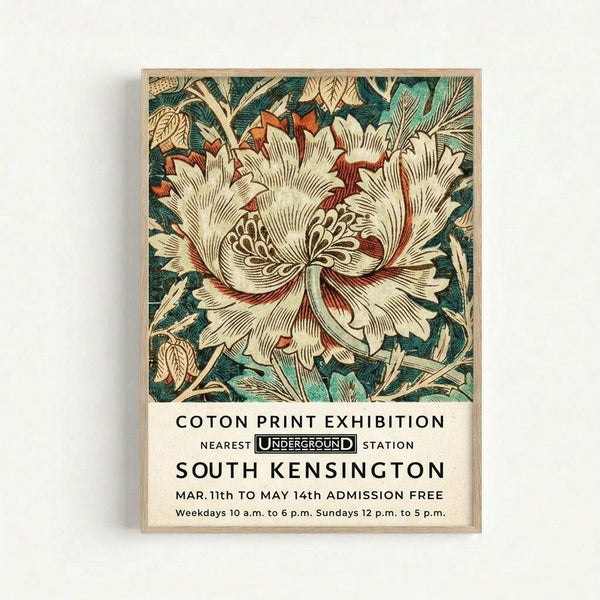 A vintage-style poster featuring an ornate botanical illustration with a large cream-colored flower with red accents and detailed stamens, surrounded by teal and green foliage. Below the floral design is black text reading "COTON PRINT EXHIBITION" with Underground logo, "SOUTH KENSINGTON" and exhibition details including dates and hours. The poster is displayed in a light wood frame against a white wall.