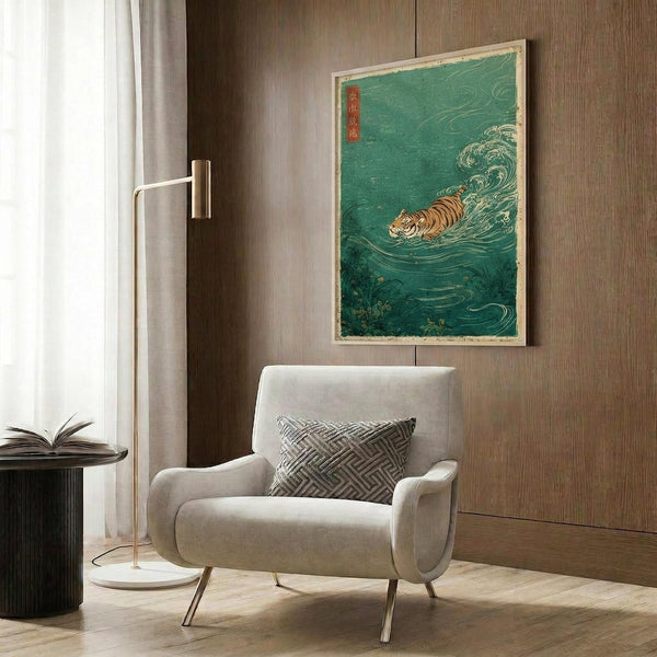 May include: Framed Japanese-style artwork featuring an orange and black striped tiger swimming through stylized turquoise-green waves, displayed on wood-paneled wall above cream-colored modern armchair with geometric patterned pillow, accompanied by brass floor lamp and dark round side table with open book.