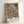 May include: Framed poster print featuring ornate Victorian floral pattern with navy blue background and cream, coral, and rust colored flowers and leaves in William Morris style, displayed in light wood frame leaning against white wall corner
