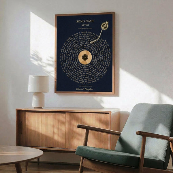 May include: Navy blue poster with spiral text design and vinyl record center, displayed in wooden frame above mid-century modern credenza. Scene shows sage green upholstered chair with wooden arms, small white table lamp, and round coffee table in sunlit room with white walls.