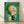 May include: Abstract modernist artwork in light wood frame leaning against white wall on wooden floor. Green textured background with geometric shapes including orange crescent, white and pink semicircle with small dark dot, yellow angular form, and black rectangular elements. Composition features overlapping circular and linear forms in earth tones with painterly, vintage appearance.