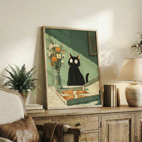 May include: Framed artwork displaying a black cat with white eyes sitting beside a vase of orange and white flowers, with a pizza box containing four slices below. The illustration features green geometric wall sections in the background. The wooden-framed piece is styled on a rustic wooden console table alongside books, a ceramic vase, and a fern plant in a cozy living room setting with beige furniture.