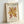 May include: Framed art print featuring abstract coral-like shapes in golden yellow and rust red colors on cream background. Text reads "MATISSE THE CUT-OUTS" at top and "BERGGRUEN & CIE" with French exhibition details at bottom. Light wood frame displayed against white wall, casting soft shadow.